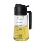Pulverizador y dispensador de aceite 450 ml Metaltex de vidrio sodocálcico transparente con escala graduada, asa lateral negra y mecanismo de spray superior