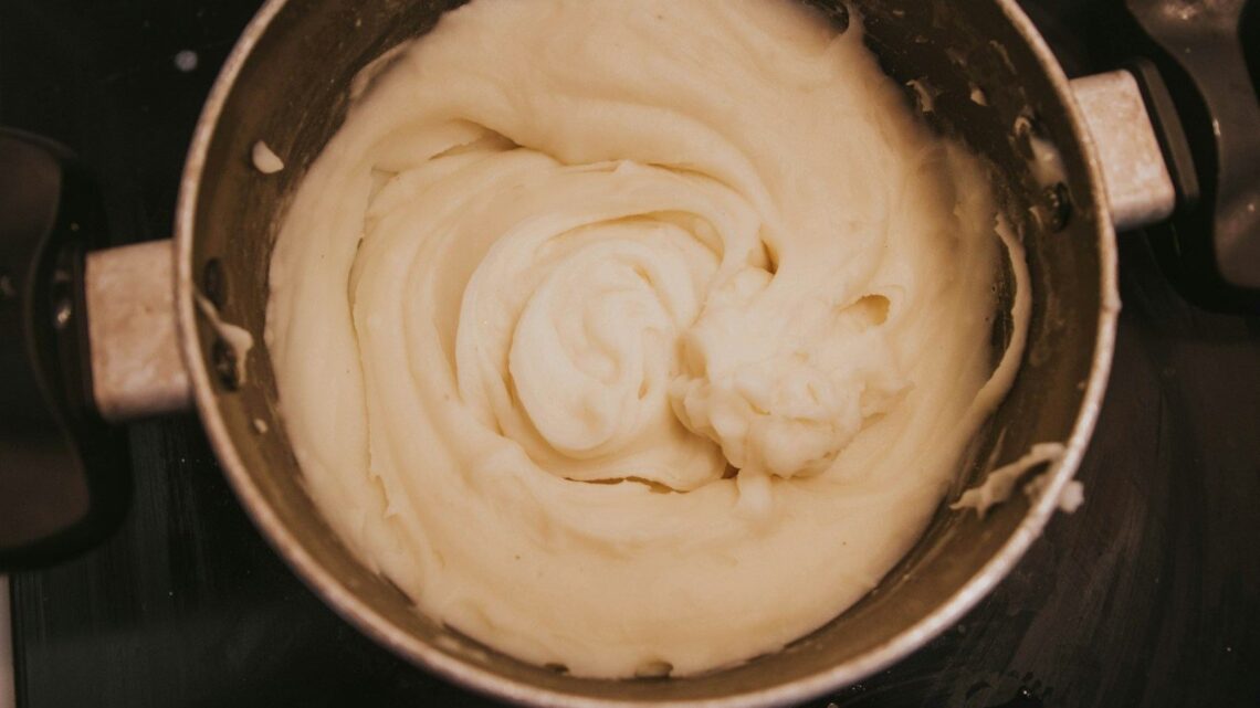 Puré de patata casero y esponjoso en una olla, hecho con pasapurés